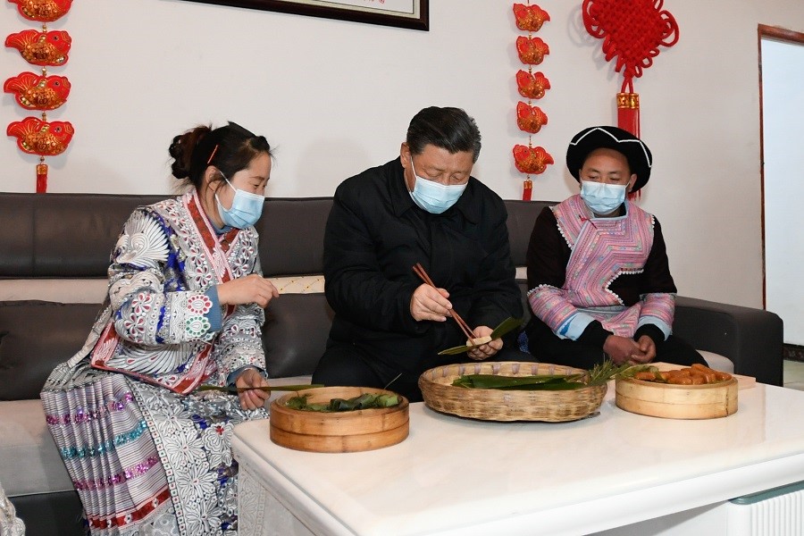 2021年2月3日下午，習(xí)近平在貴州畢節(jié)市黔西縣新仁苗族鄉(xiāng)化屋村苗族村民趙玉學(xué)家，同一家人邊聊家常邊制作當(dāng)?shù)貍鹘y(tǒng)節(jié)日食品黃粑。新華社記者 李學(xué)仁 攝